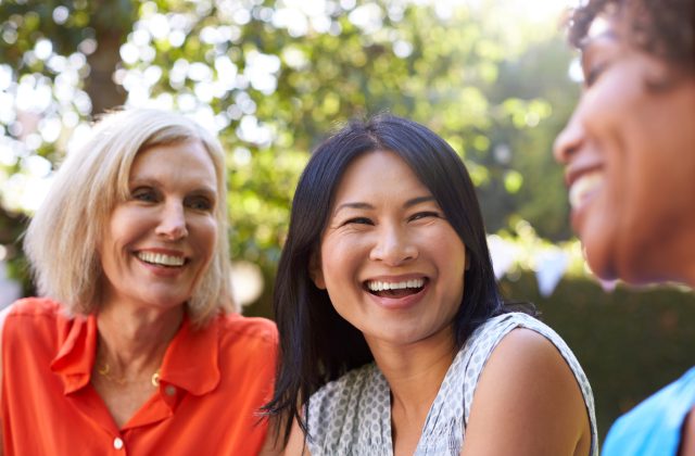 Two women smiling together at a community event
