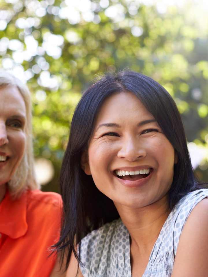 Two women smiling together at a community event