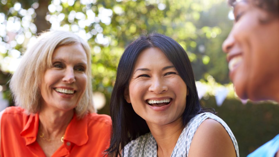 Two women smiling together at a community event